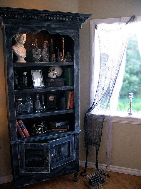 an old black bookcase in front of a window