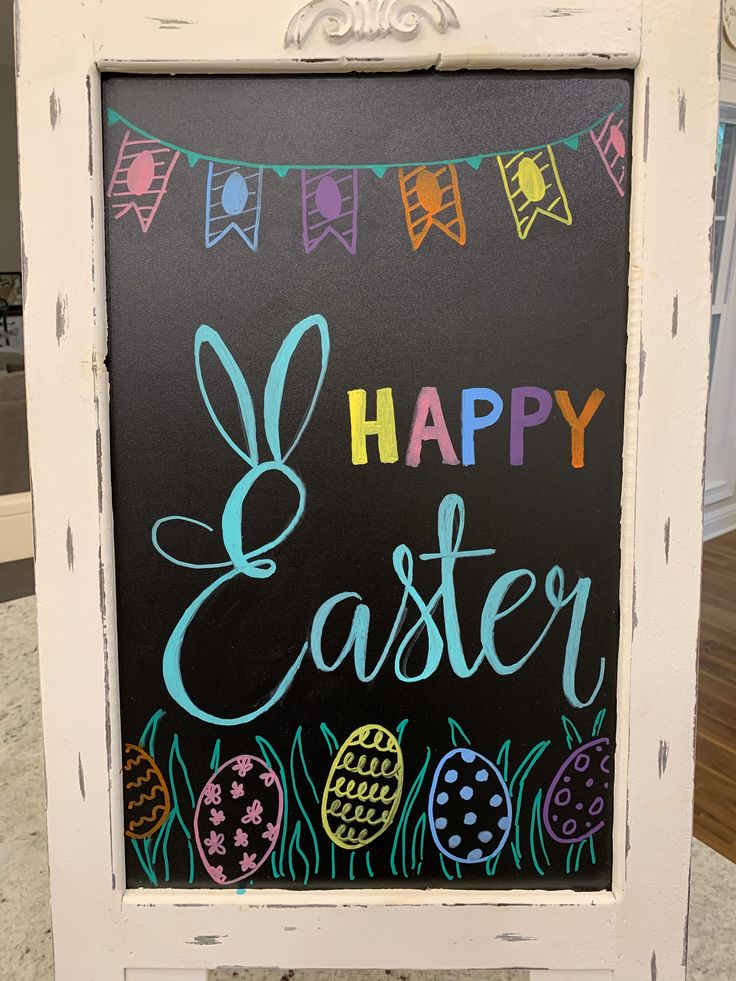 a chalkboard sign with the words happy easter painted on it