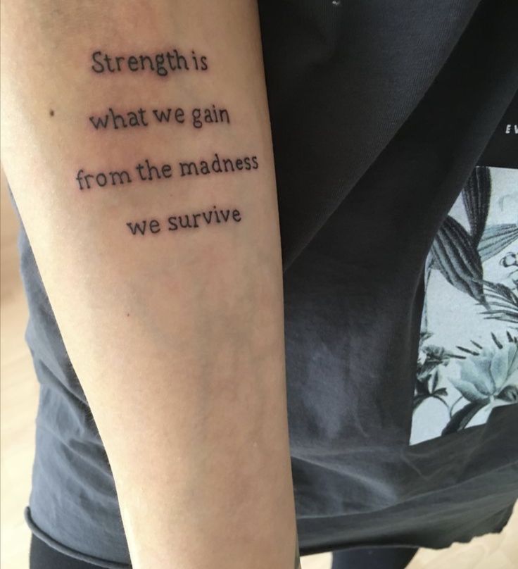 a person with a tattoo saying strength is what we gain from the madness we survive