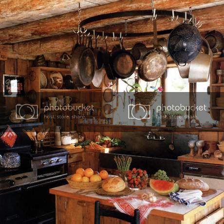 a kitchen filled with lots of pots and pans hanging from the ceiling next to an oven