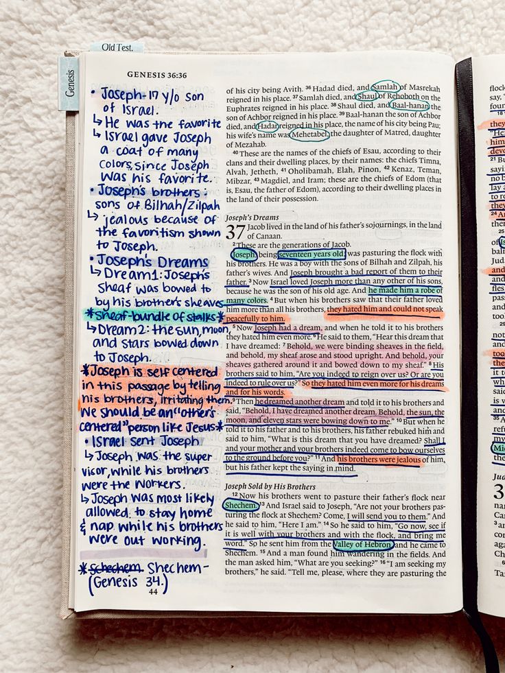 an open bible with colorful writing on it