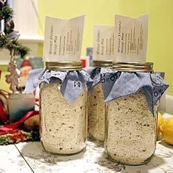 two jars filled with rice sitting on top of a counter next to a christmas tree