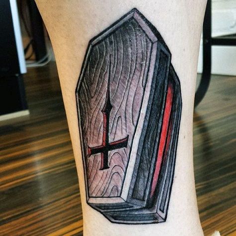 a tattoo on the leg of a person with a cross and an open book in it