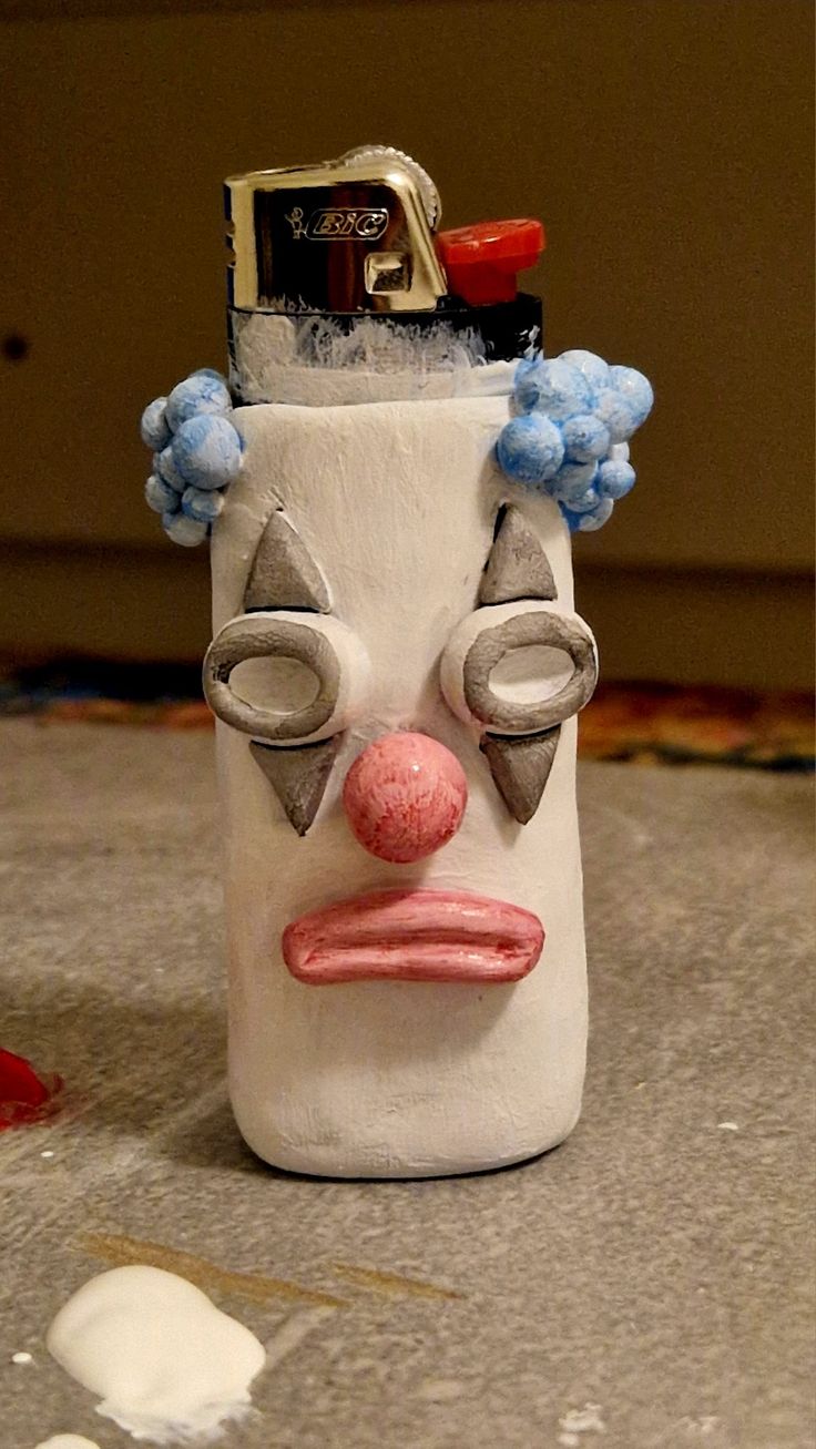 a white and blue ceramic face on top of a counter next to a canister