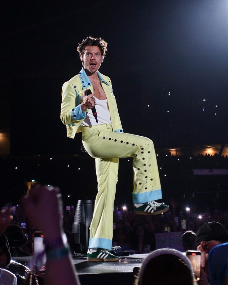 a male in a yellow suit is on stage