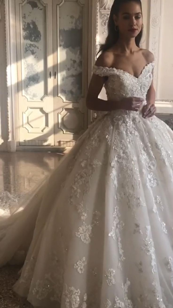 a woman in a white wedding dress standing next to a mirror