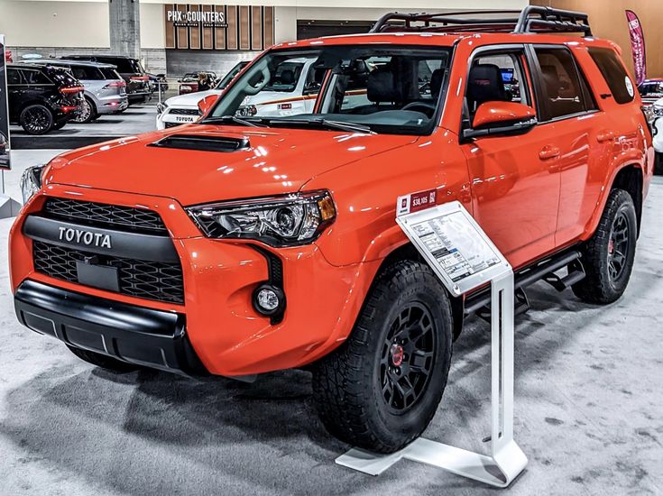 an orange toyota truck is on display in a showroom