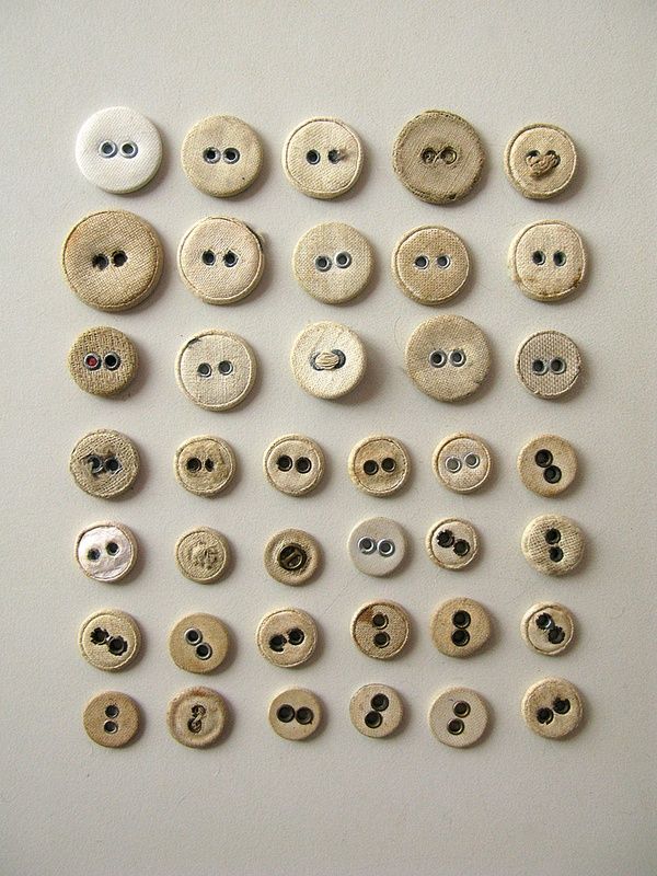 several different types of buttons on a white surface with holes in the middle and bottom