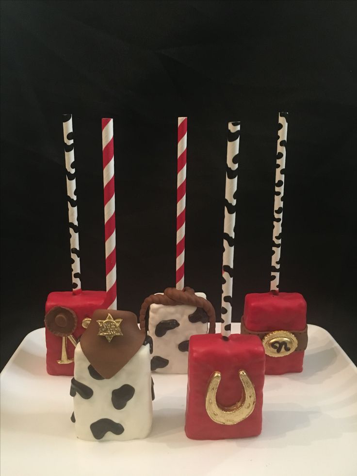 the cake is decorated with candles and cowgirls on it's sides, along with other decorations