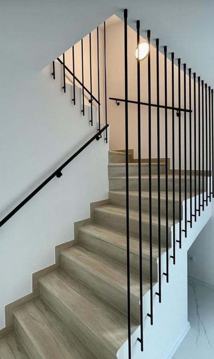 a set of stairs with black railings and white walls