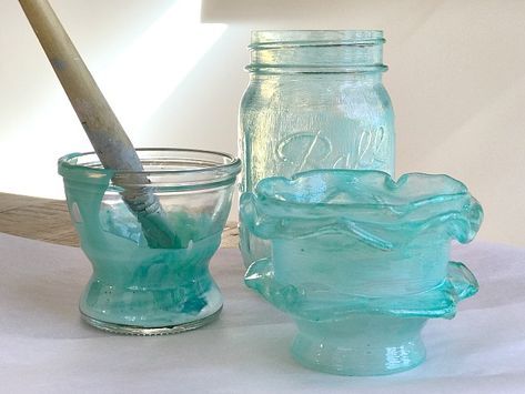 three glass jars with spoons in them sitting on a white table cloth next to each other