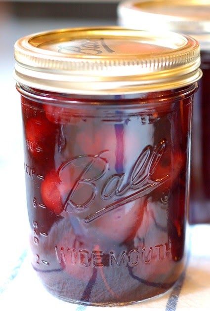 two jars filled with jelly sitting on top of a table