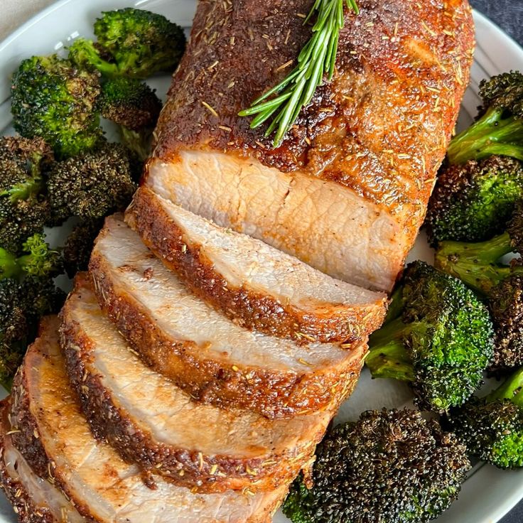 sliced pork and broccoli on a plate with seasoning sprinkled on top