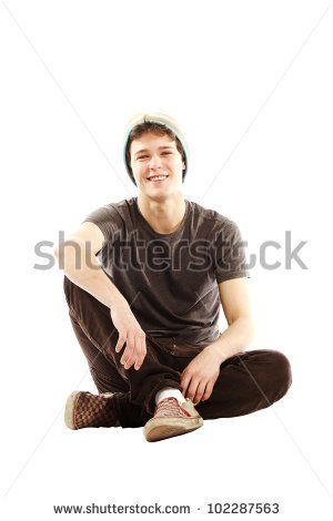 a young man sitting on the floor with his legs crossed