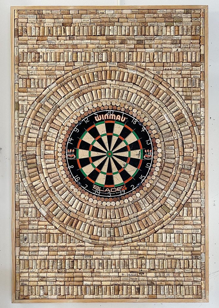 a dart in the center of a wall made out of wood and woven with words on it