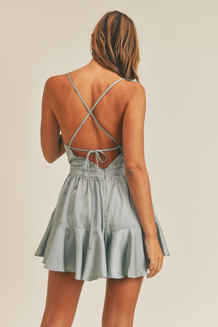 This is a lovely ruffle romper with back lace-up details and an invisible zipper at the back. For a summer outfit, pair it with a summer bag from our eco-friendly collection and flat sandals. Wear a stunning gown to draw attention to your hourglass figure. Your captivating beauty will captivate people. This backless smocked mini dress goes with everything for an effortlessly chic look. It's the ideal addition to your spring wardrobe. This cute silk print midi dress is made of 100% polyester. The Summer Backless Dress With Ruffle Hem, Backless Dress With Ruffle Hem For Garden Party, Summer Backless Ruffled Dress, Summer Dresses With Lace-up Back For Spring, Chic Ruffled Dress With Strappy Back, Chic Spring Dress With Strappy Back, Flirty Backless Sundress For Spring, Summer Garden Party Dresses With Strappy Back, Chic Dresses With Ruffles And Strappy Back