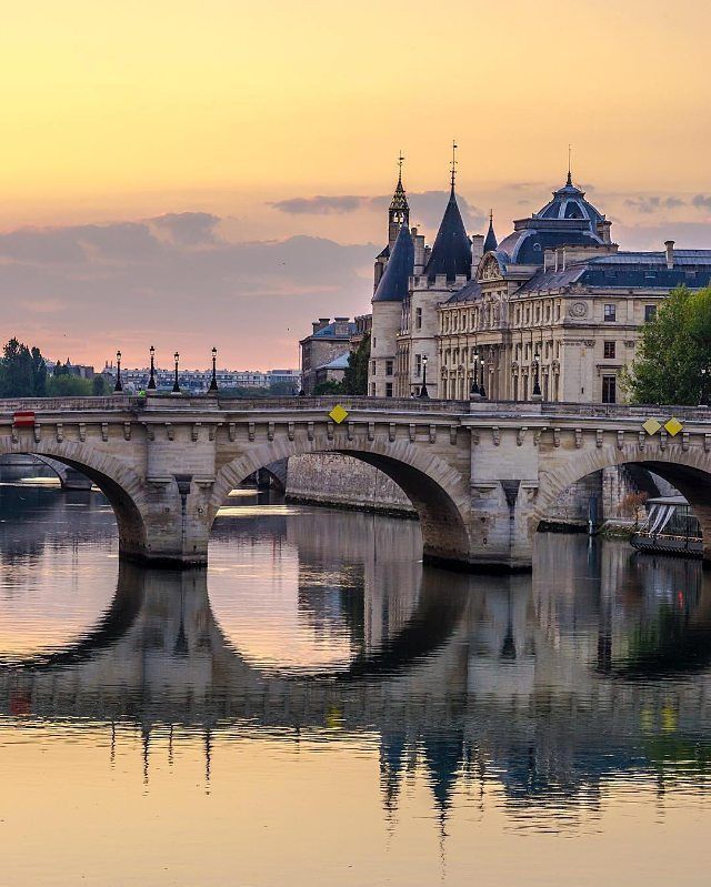 a bridge that is over some water with buildings in the background