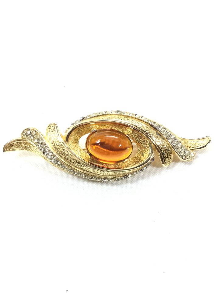 Exquisite CASTLECLIFF brooch all done on brilliant gold plated metal.  Huge oval openback topaz cabochon and open all around it.  Waves of brilliant textured gold and pave clear chatons , three waves to the right and three to the left.  Measuring 3 1/2" by 1 3/8".  BREATHTAKINGLY BEAUTIFUL! Luxury Oval Cabochon Brooch Jewelry, Unique Oval Cabochon Brooches, Luxury Oval Cabochon Brooch, Unique Gold Brooch With Cabochon, Luxury Cabochon Pendant Brooch, Luxury Silver Cabochon Brooch, Luxury Yellow Gold Cabochon Brooch, Luxury Modernist Cabochon Jewelry, Luxury Art Nouveau Cabochon Brooch