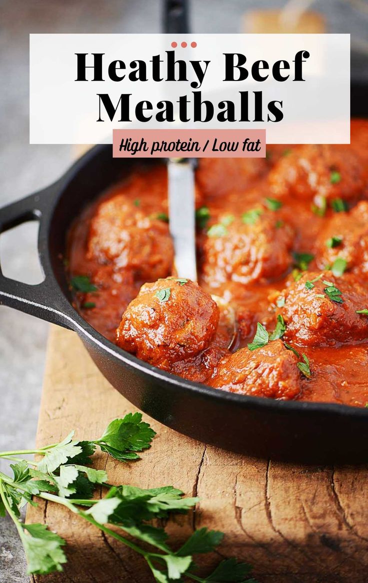 meatballs with tomato sauce and parsley in a skillet on a cutting board