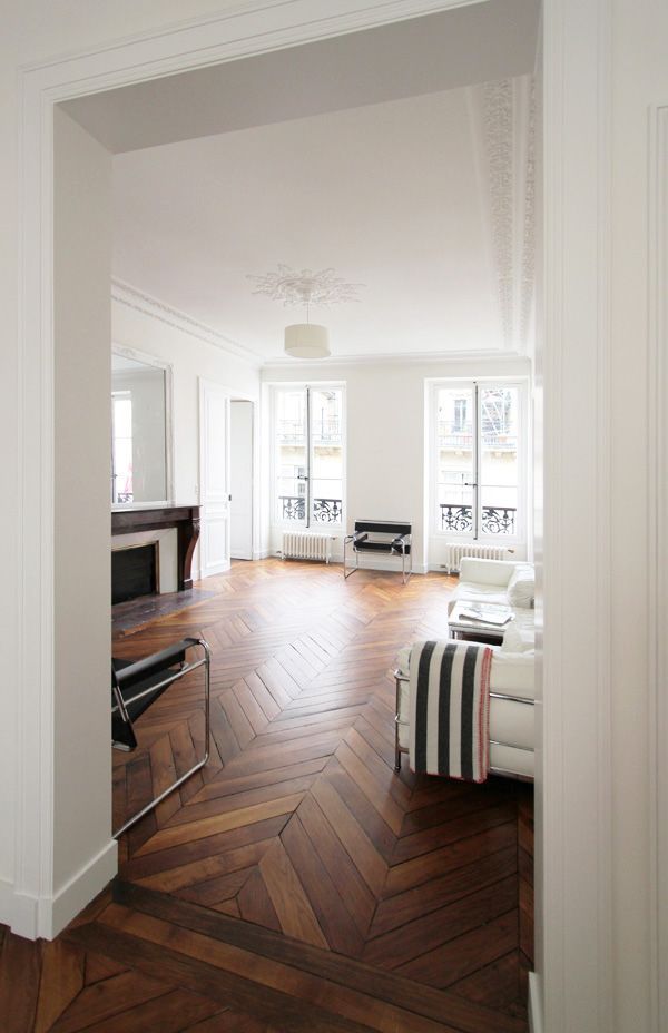 an empty living room with wood floors and white walls