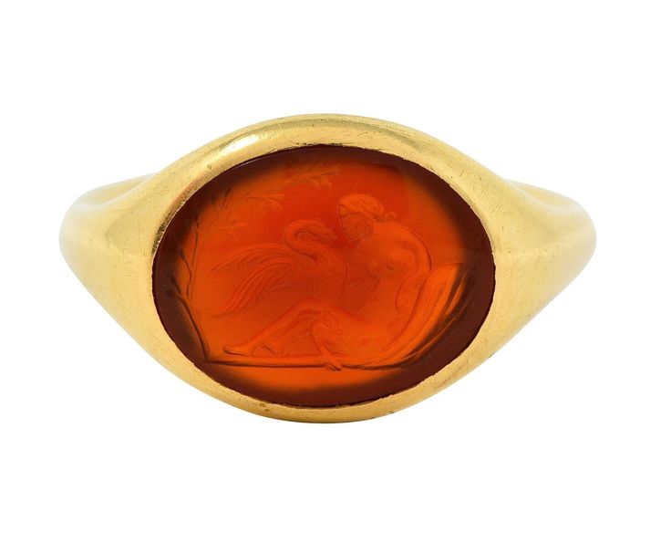 Centering an oval-shaped carnelian tablet carved with intaglio depicting a woman and swan Based on the Greek myth of the figure Leda and The Swan (Zeus)  Translucent reddish-orange and measuring 10.0 x 13.0 mm  Flush set with a contoured gold surround  Stamped with French hallmarks for 18 karat gold With partial maker's mark Circa: 1870s Ring size: 6 1/4 and sizable Measures north to south 11.6 mm and sits 3.6 mm high Total weight: 5.8 grams Stock Number: We-12781 Leda And The Swan, Mid Century Contemporary, Journal Jewelry, Greek Myth, Reddish Orange, Greek Myths, Ring Pictures, Victorian Art, Maker's Mark