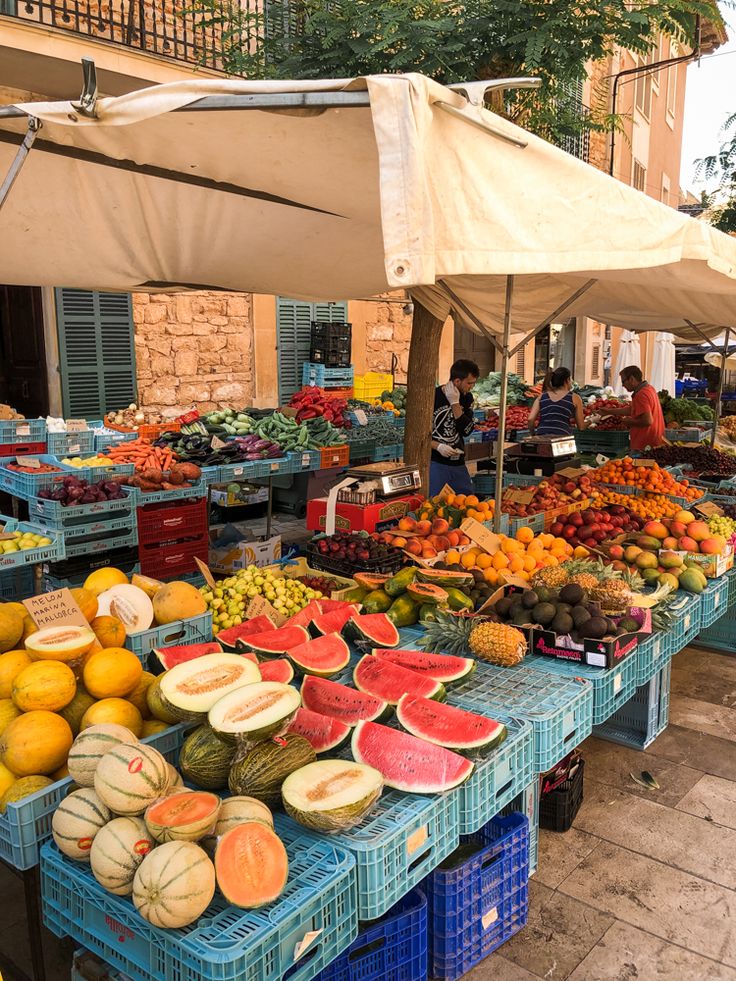 an outdoor market with lots of fruits and vegetables