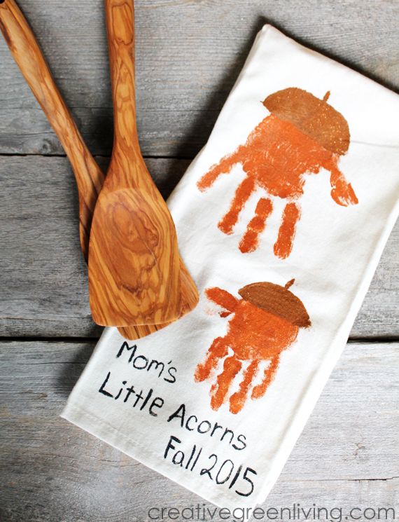 two wooden spoons sitting next to a tea towel with handprinted orange jellyfish on it