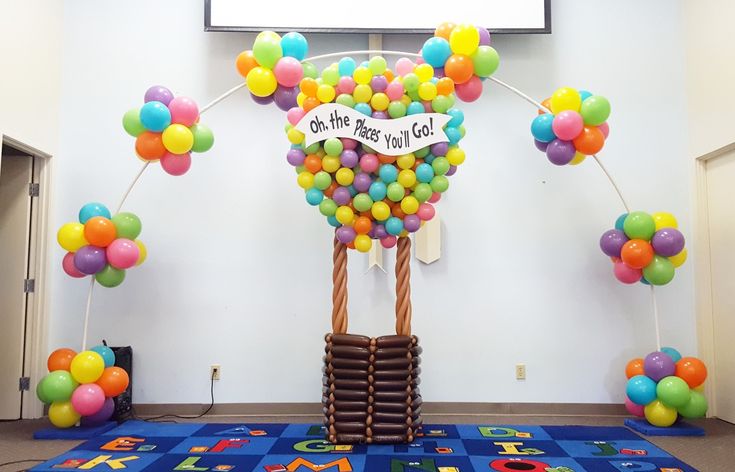 a room decorated with balloons and a sign that says, on the first day of school