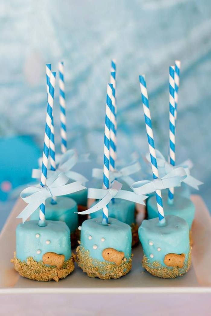 blue and white desserts with candles in the shape of sheep's on them