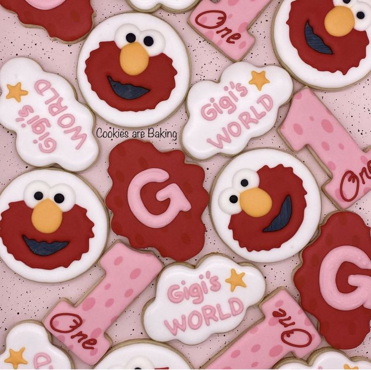 cookies decorated like sesame street characters are displayed on a pink tablecloth with the words g is for cookie art baking