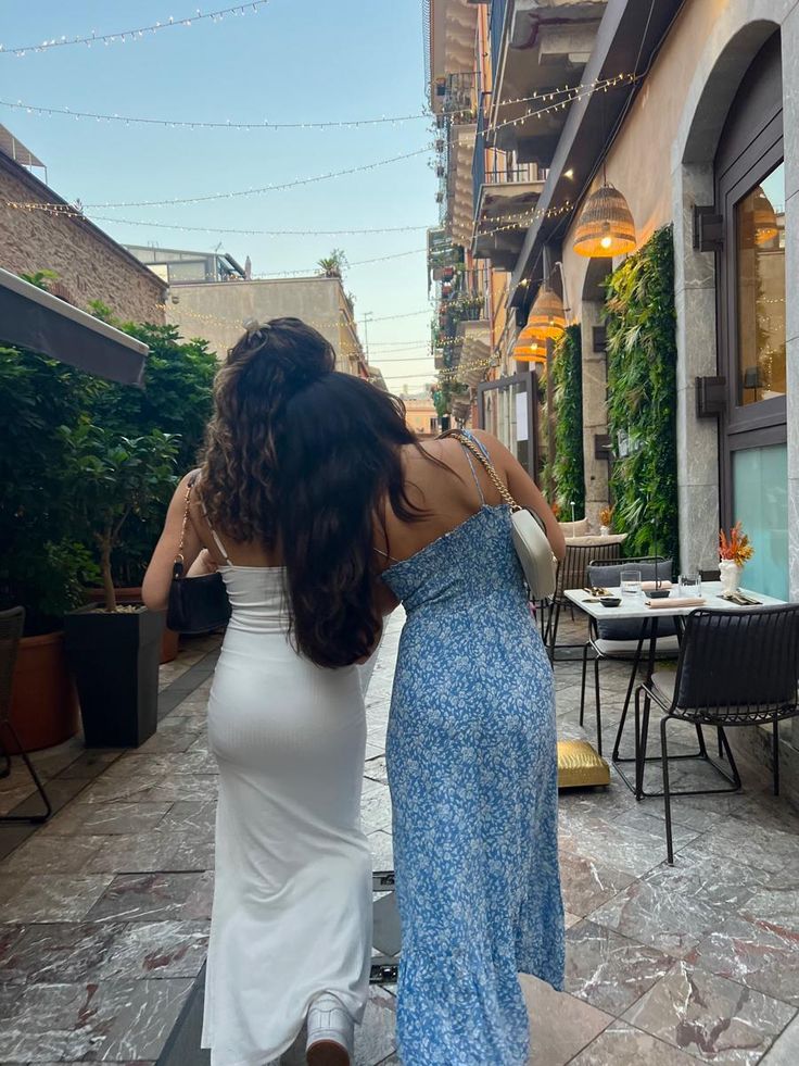 two women are walking down the street together