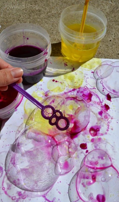 a person is painting with purple and yellow paint