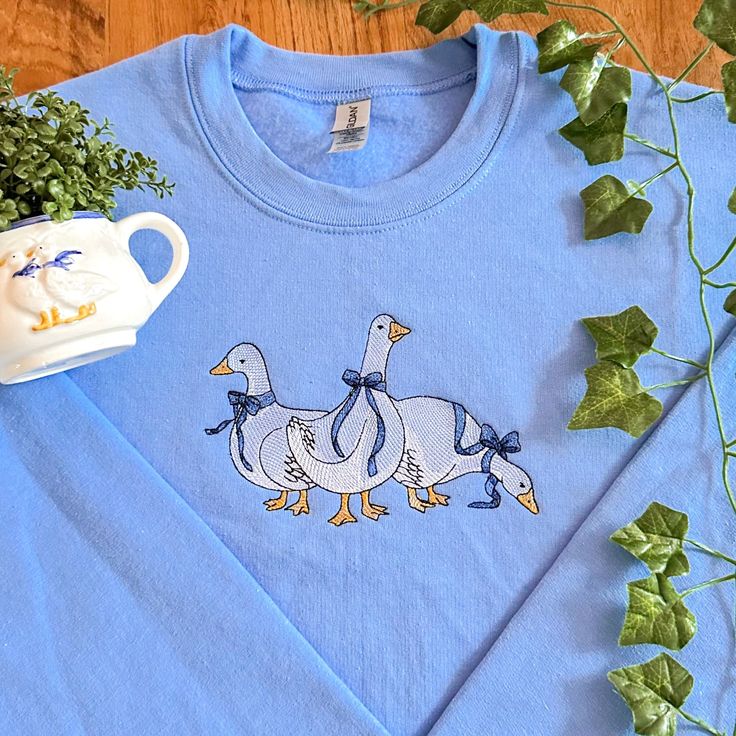 Dainty Geese Embroidered Sweatshirt - Etsy Blue Sweater With Embroidered Text For Fall, Blue Cotton Sweater With Embroidered Logo, Spring Cotton Sweater With Embroidered Logo, Blue Embroidered Text Sweater For Fall, Crew Cotton Top With Machine Embroidery, Cotton Crew Top With Machine Embroidery, Cotton Crew Neck Top With Machine Embroidery, Blue Embroidered T-shirt For Fall, Custom Embroidered Cotton Crew Neck Sweater