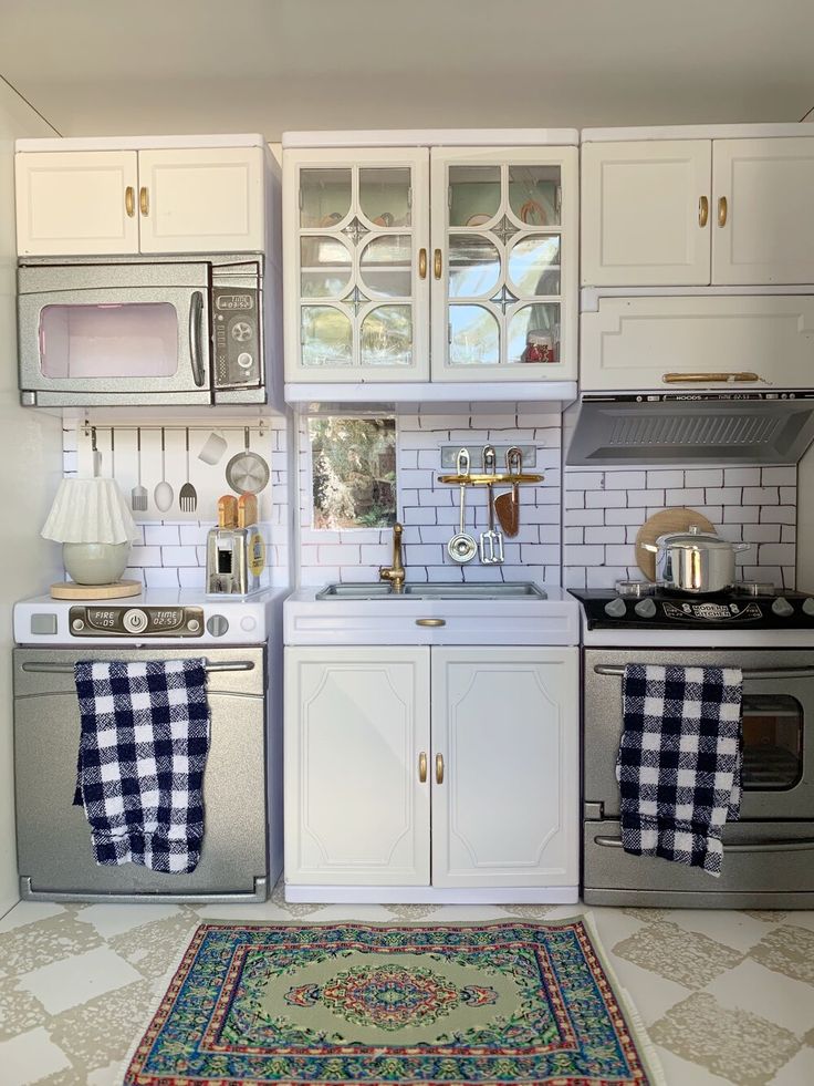 a kitchen with white cabinets and checkered rugs on the floor next to an oven