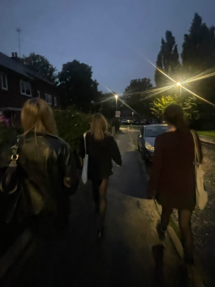 three women walking down the street at night