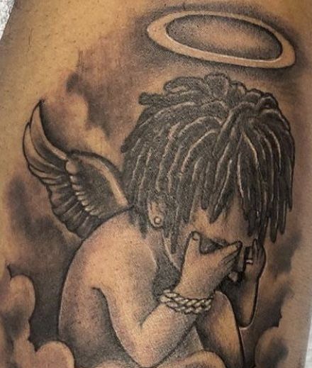 an angel tattoo on the back of a man's arm