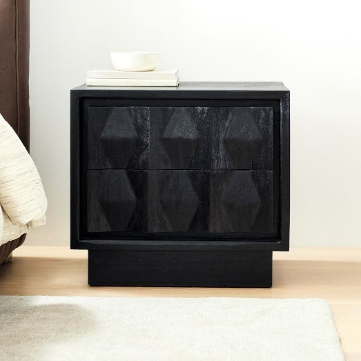 a black cabinet sitting on top of a wooden floor next to a white rug and chair