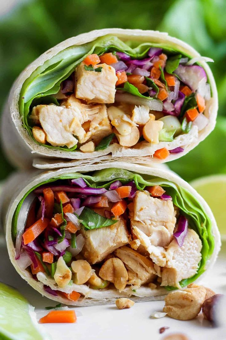 two wraps filled with chicken, lettuce and carrots on top of each other