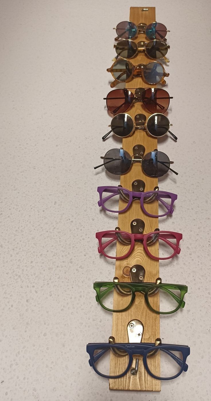 a wooden rack with several pairs of glasses on it