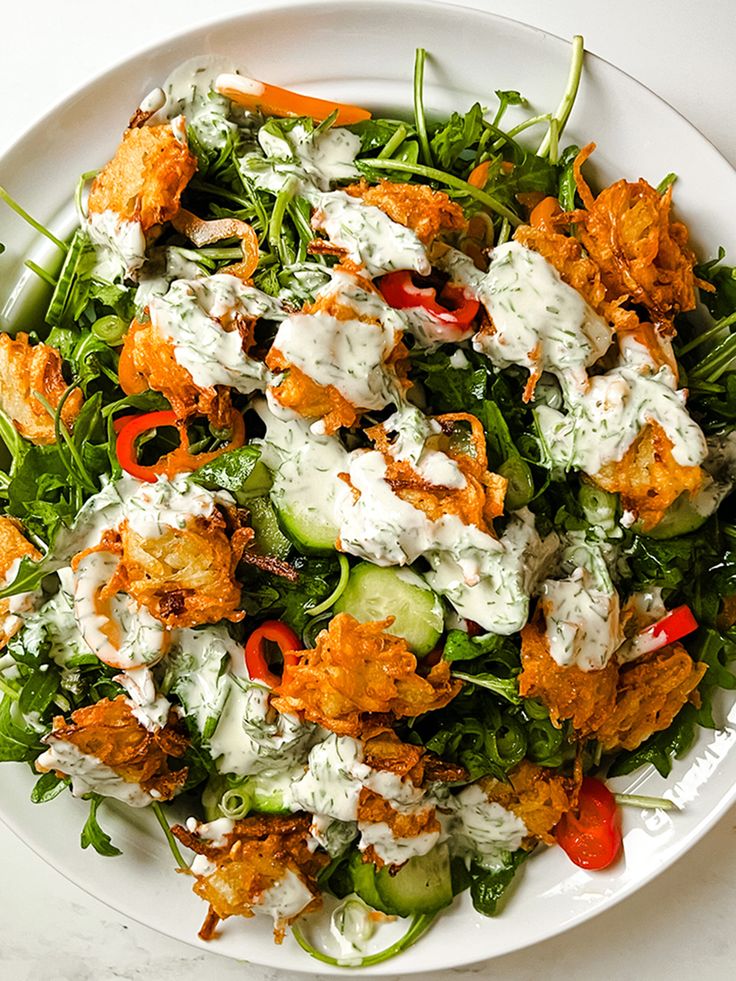 a white plate topped with salad covered in dressing