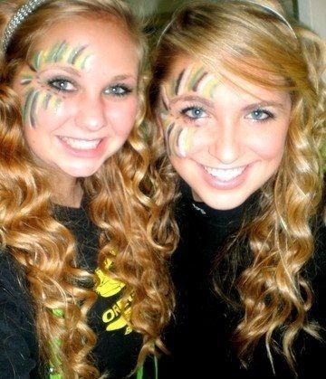 two girls with face paint smiling for the camera