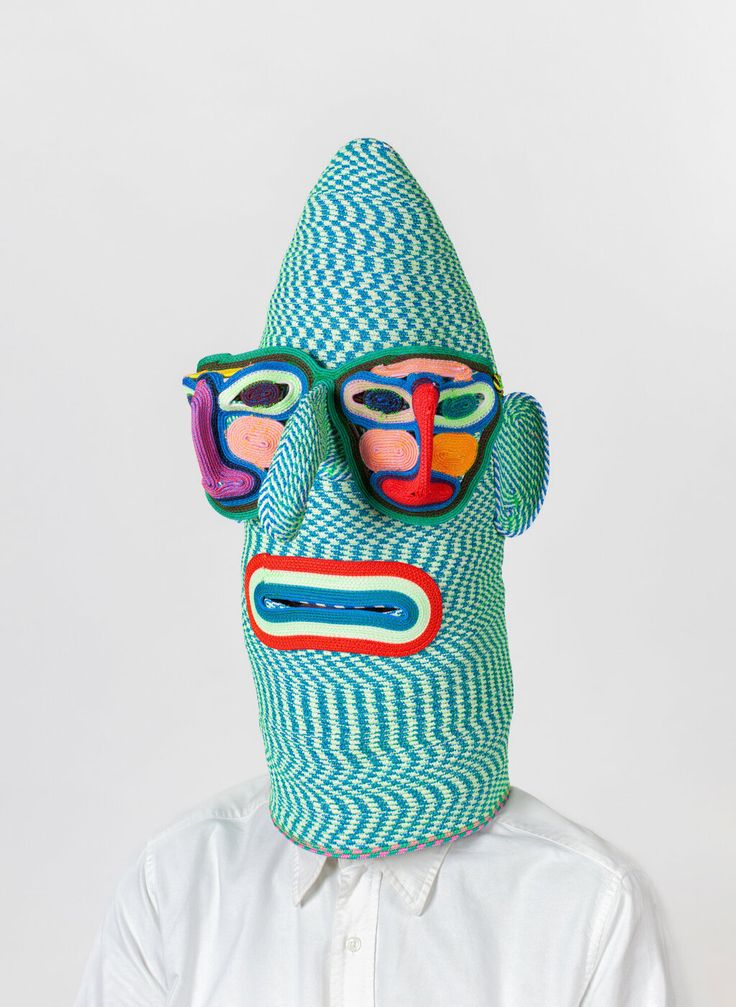 a man wearing a blue mask with two colorful faces on it's face and the other half of his head