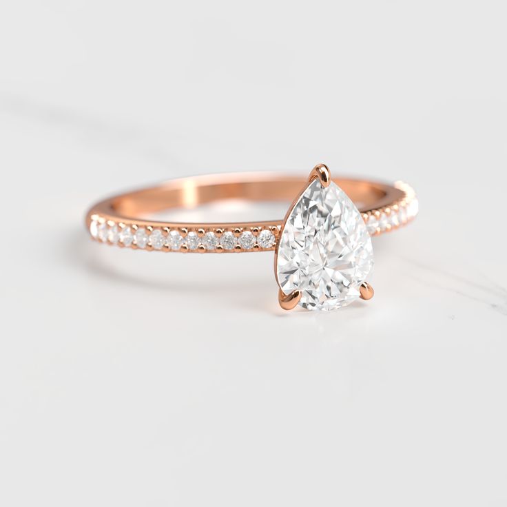 a rose gold engagement ring with a pear shaped diamond