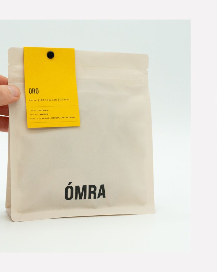 a hand holding a bag with a yellow tag on it