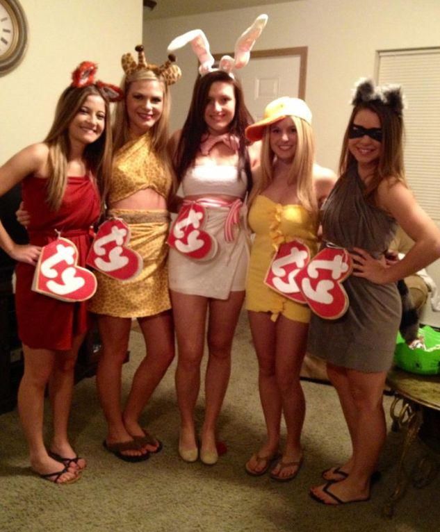 four women dressed up in costumes posing for the camera with one holding a sign that says 35