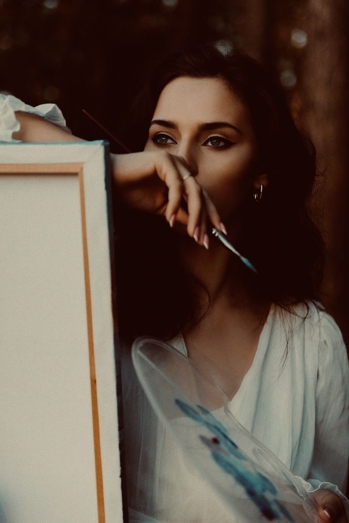 a woman leaning against a box holding a knife