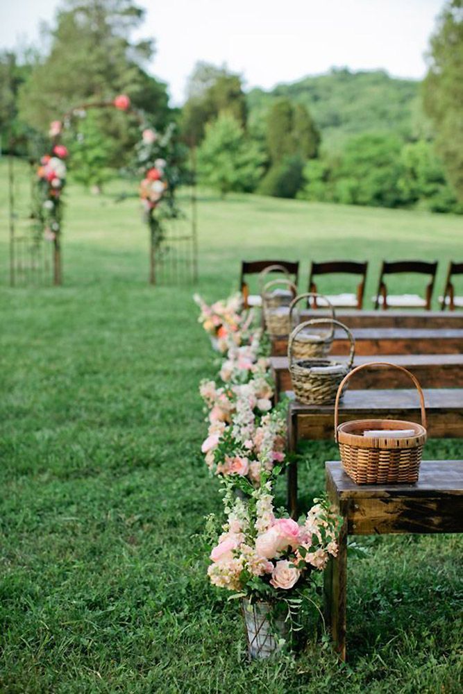 a row of wooden benches sitting on top of a lush green field