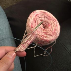 someone is knitting yarn with a pair of scissors