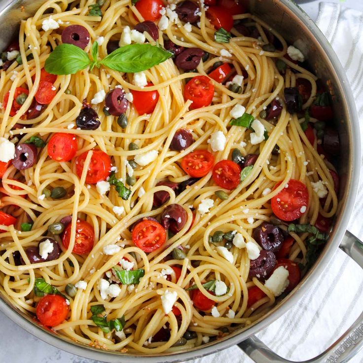 pasta with olives, tomatoes and feta cheese in a pan