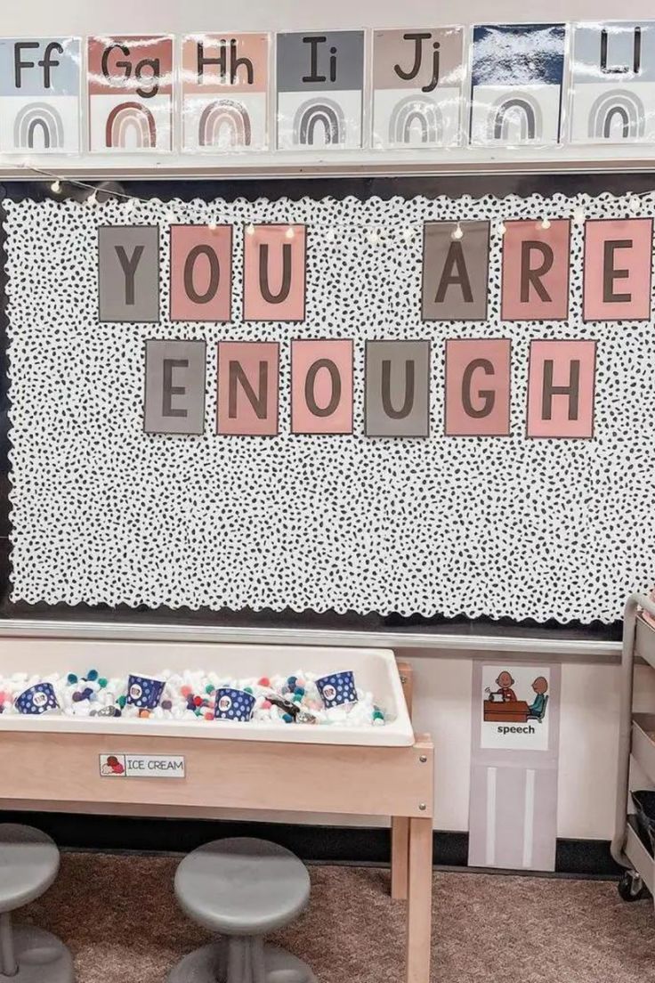 a child's playroom with two stools and a wall that says you are enough